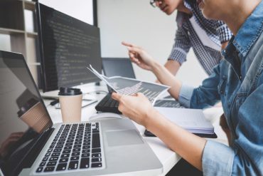 Programmers cooperating at Developing programming and website working in a software develop company office, writing codes and typing data code