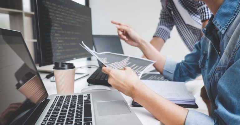 Programmers cooperating at Developing programming and website working in a software develop company office, writing codes and typing data code