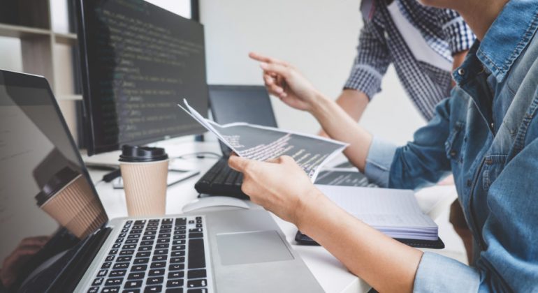 Programmers cooperating at Developing programming and website working in a software develop company office, writing codes and typing data code
